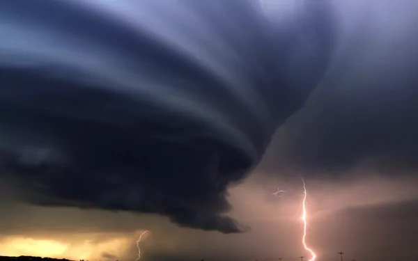 A dramatic HD wallpaper capturing a powerful tornado formation with swirling clouds and striking lightning, showcasing the awe-inspiring beauty of nature's storms.