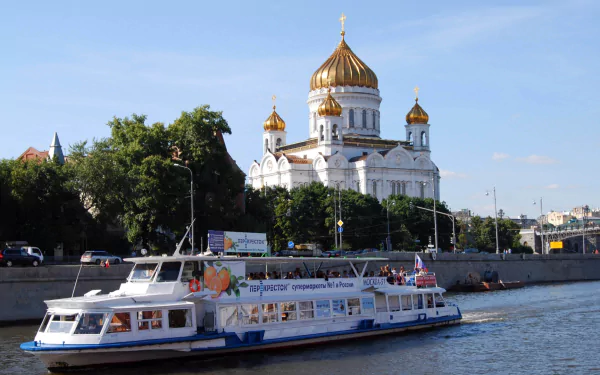 Religious HD PC desktop wallpaper: Cathedral of Christ the Saviour with golden domes by the Moskva River and a sightseeing boat in the foreground.