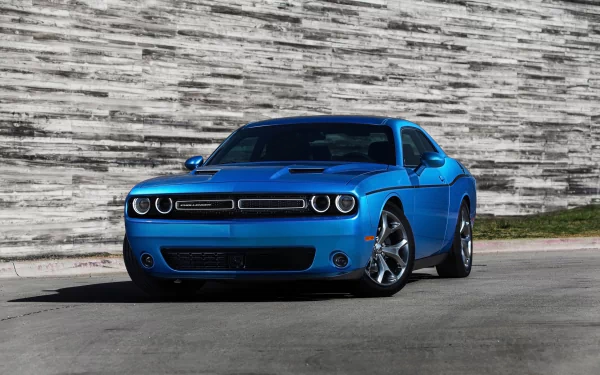 A striking blue Dodge Challenger captures attention, showcasing sleek lines against a textured stone background—a stunning HD PC desktop wallpaper and background.