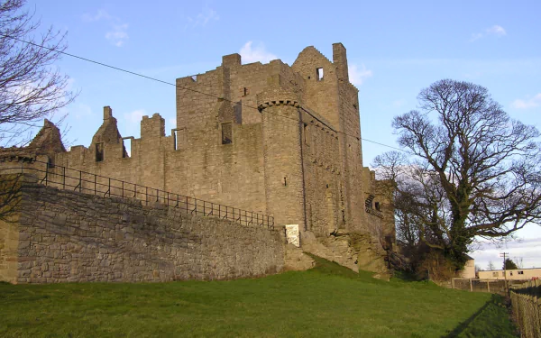 HD desktop wallpaper showcasing the historic man-made Craigmillar Castle against a clear sky with surrounding stone walls and leafless trees.