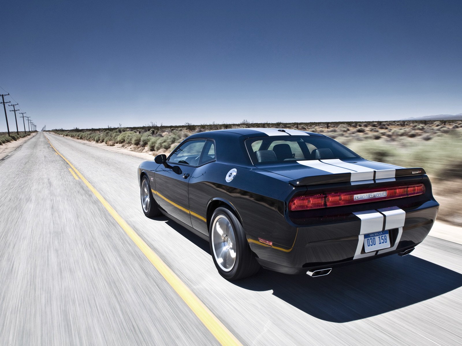 HD PC desktop wallpaper of a black Dodge Challenger SRT8 392 with white racing stripes driving down an empty desert highway.