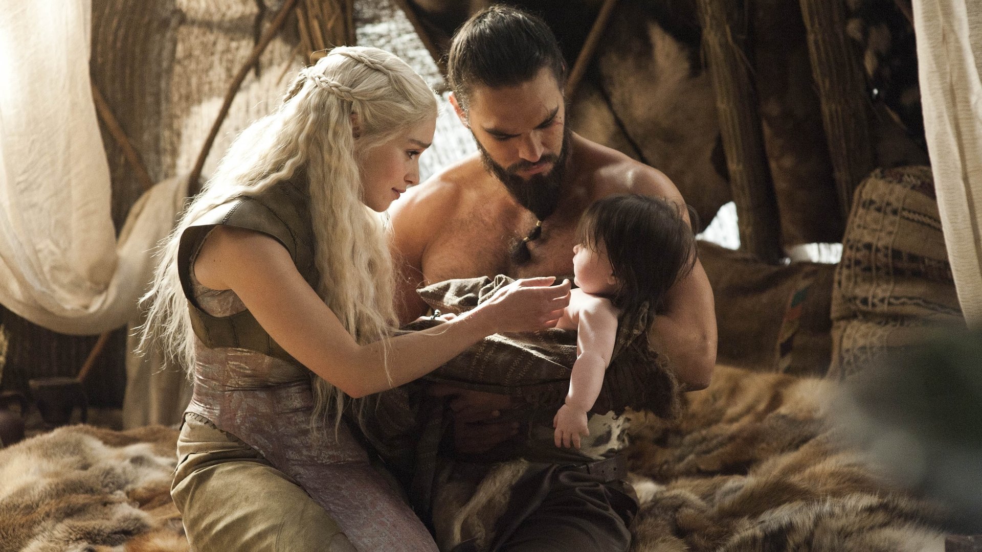 Jason Momoa as Drogo and Emilia Clarke as Daenerys Targaryen tenderly interact with a child in this 4K Ultra HD wallpaper from the TV show Game of Thrones.