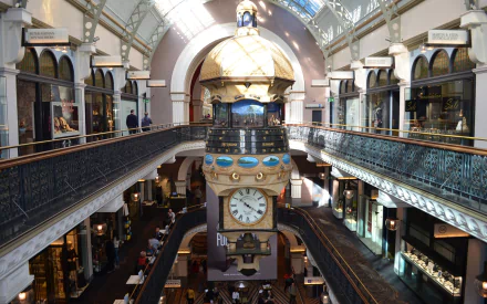 Interior view of the Queen Victoria Building in Sydney, Australia, showcasing its historic architecture, central clock, and shoppers in a vibrant, well-lit space.