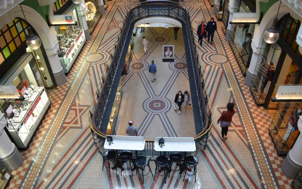Interior view of Sydney's Queen Victoria Building in Australia, showcasing elegant architecture, mosaic floors, shops, and people walking through the historic marketplace.