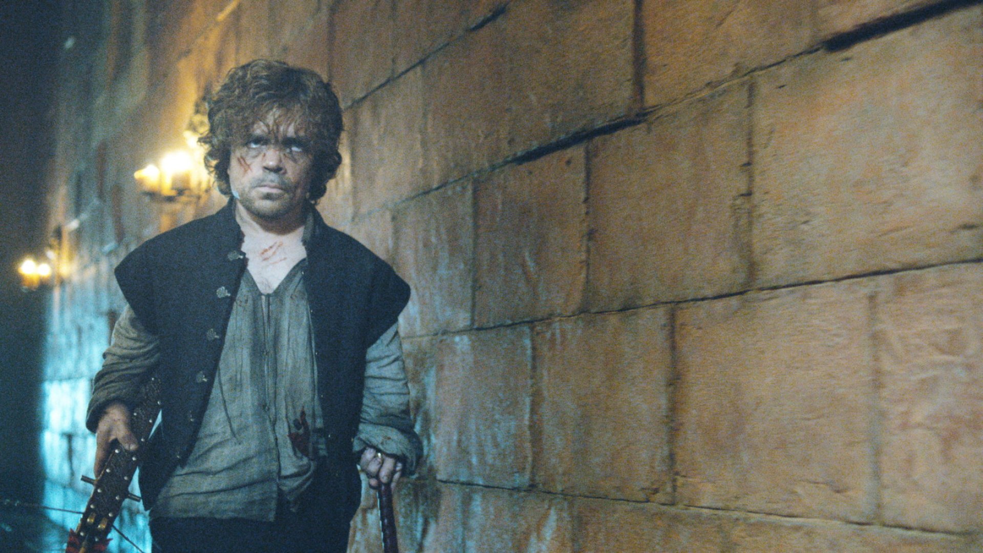 Peter Dinklage as Tyrion Lannister, walking through a dimly lit stone corridor from the TV show Game of Thrones, capturing a moment of intrigue and intensity.