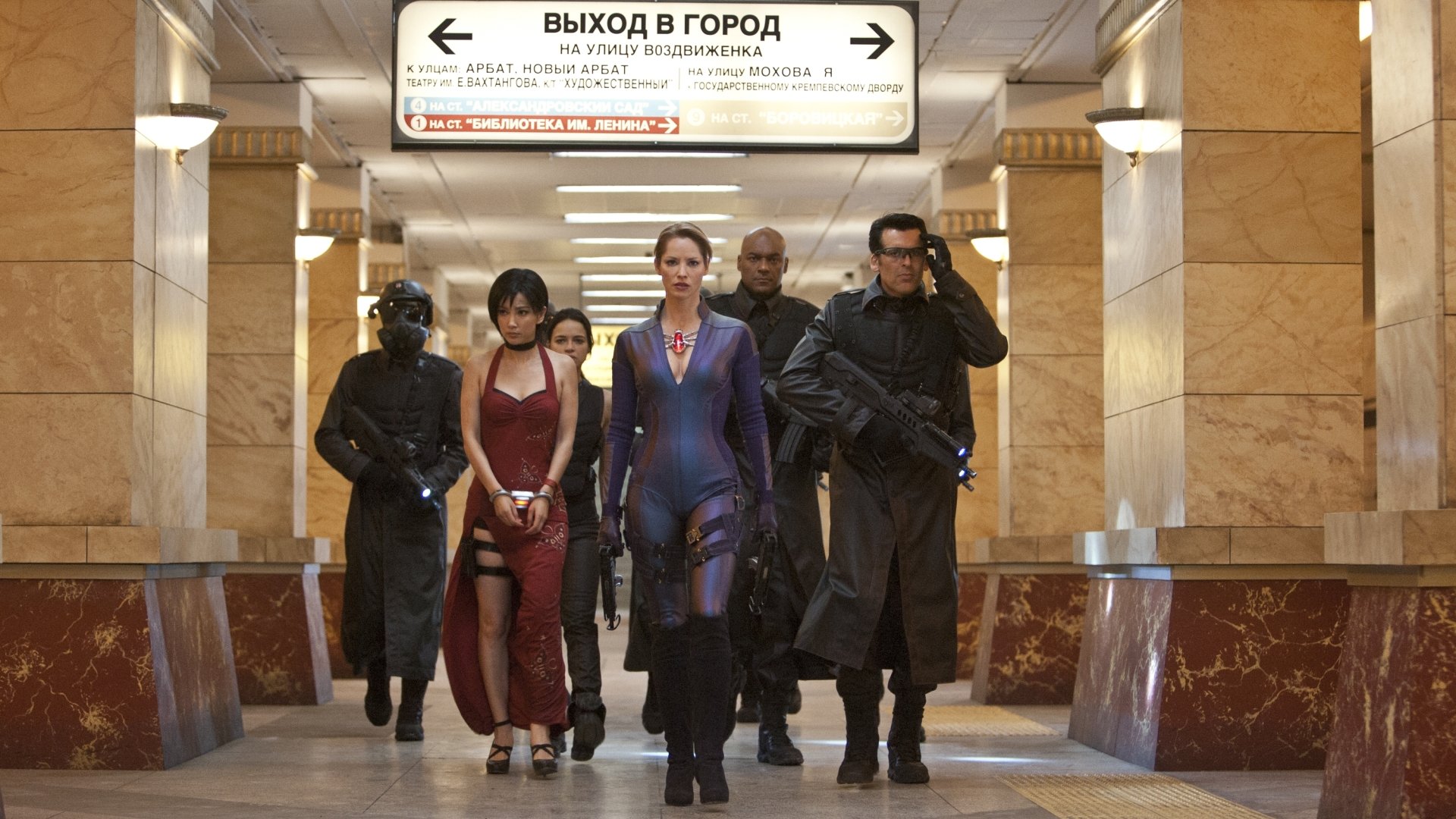 HD PC desktop wallpaper featuring a scene from the movie Resident Evil: Retribution with five characters walking confidently through a subway corridor.