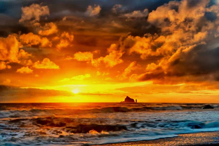 A stunning sunset over the ocean, with waves gently crashing on the beach. Vibrant orange and golden hues contrast with dark clouds, creating a serene natural landscape.