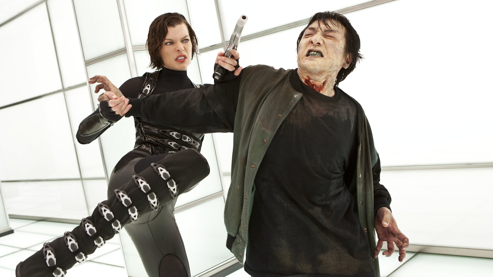 Resident Evil: Retribution 2K Quad HD PC desktop wallpaper — woman in black combat suit fires a pistol while kicking a bloodied man in a bright, geometric room.