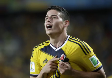 HD desktop wallpaper featuring a man in a yellow soccer kit looking upwards with passion and intensity.