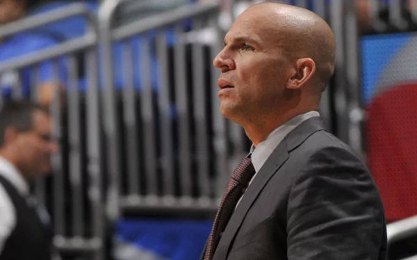 HD desktop wallpaper featuring a profile view of Jason Kidd in a suit, focused on the sidelines of a basketball court.