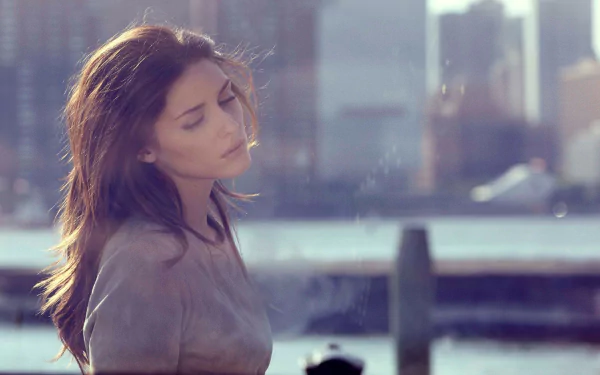 HD desktop wallpaper featuring Olivia Palermo in a contemplative pose with an urban waterfront backdrop.