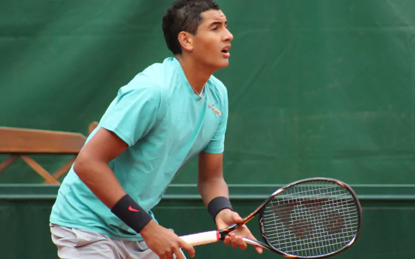 HD desktop wallpaper of tennis player in action on court, poised and focused during a game.