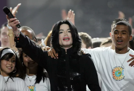 Michael Jackson performs passionately on stage, surrounded by fans, captured in an HD desktop wallpaper celebrating his iconic music legacy.
