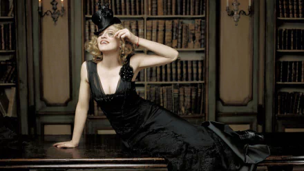 HD PC desktop wallpaper featuring Madonna in an elegant black gown and stylish hat, posed gracefully against a vintage bookshelf backdrop, capturing a classic music icon look.