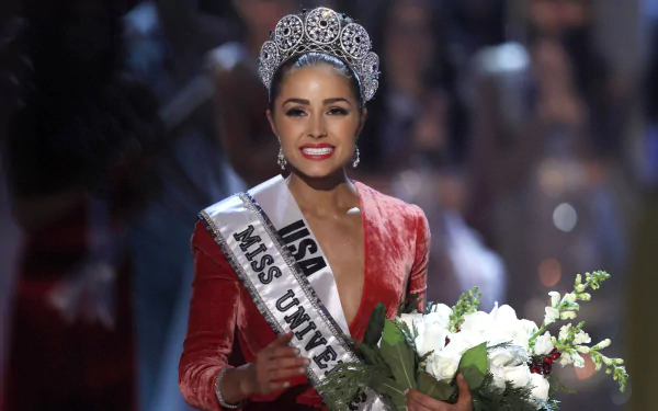 HD desktop wallpaper featuring Olivia Culpo, American model and Miss Universe, smiling confidently with her crown, sash, and bouquet of flowers on stage.
