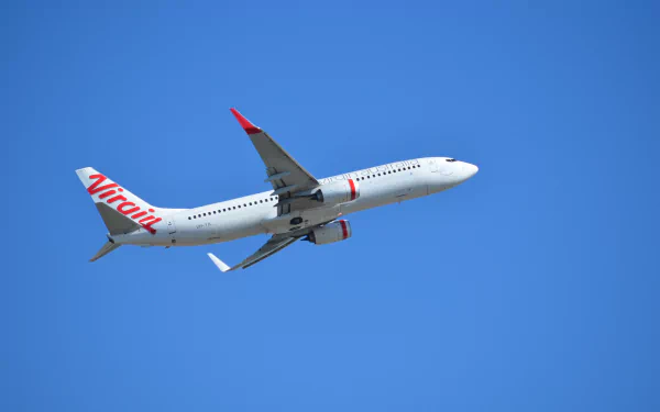 Boeing 737 soaring through a bright blue sky, showcasing its sleek design and vibrant livery, captures the essence of aviation excellence. A stunning HD desktop wallpaper for aircraft enthusiasts.