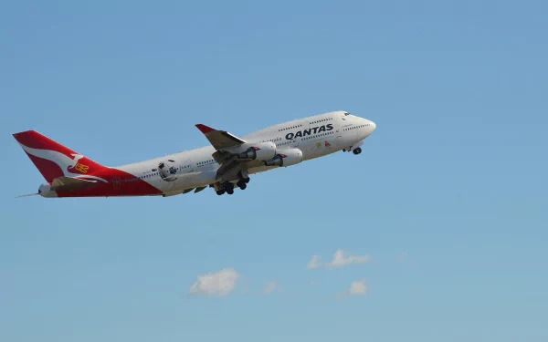HD wallpaper featuring a Qantas Boeing 747 aircraft ascending against a clear blue sky, showcasing one of the iconic vehicles in aviation.