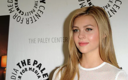 American actress Nicola Peltz poses at a media event, featured in an HD PC desktop wallpaper and background.