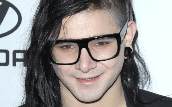 HD desktop wallpaper featuring Skrillex, known for his influential music, showcases his unique style with long hair and stylish glasses.