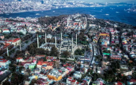 Aerial view of Istanbul's Sultan Ahmed Mosque, also known as the Blue Mosque, surrounded by vibrant neighborhoods and the Bosphorus, showcasing the city's rich architectural heritage.