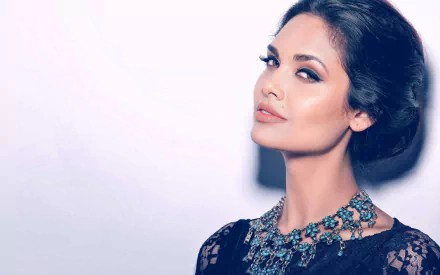 Esha Gupta, the Indian actress, poses elegantly in this HD desktop wallpaper, showcasing her striking features and stunning jewelry against a soft background.