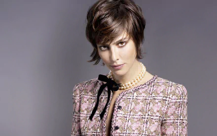 HD desktop wallpaper: portrait of a short-haired actress in a pink tweed jacket and pearl necklace, posed against a soft gray background.