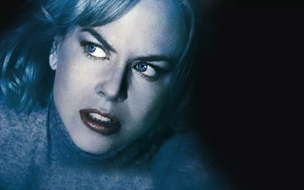HD PC desktop wallpaper for the movie The Invasion: close-up of a pale, intense woman with blue-tinted hair and a piercing gaze against a dark background.