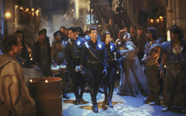 HD PC desktop wallpaper featuring a scene from the movie Demolition Man, showcasing characters in futuristic urban attire amidst a tense crowd.