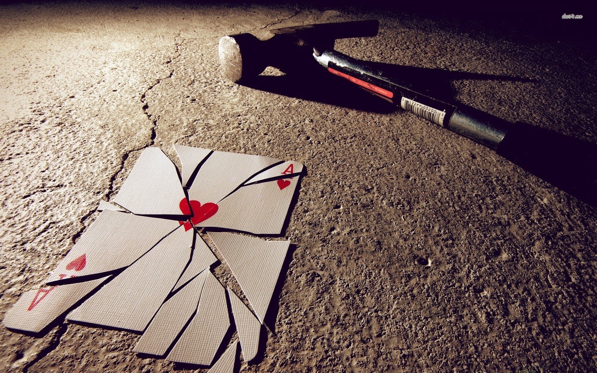 HD desktop wallpaper showing a man-made scene with shattered playing cards forming a heart on the ground and a hammer lying nearby, evoking poker-themed imagery.