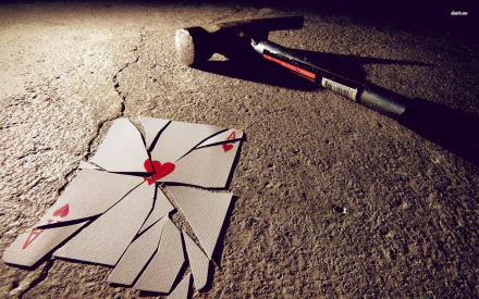 HD desktop wallpaper showing a man-made scene with shattered playing cards forming a heart on the ground and a hammer lying nearby, evoking poker-themed imagery.