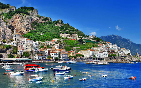 A vibrant 4K Ultra HD view of Positano, a man-made coastal town in Salerno, Italy, featuring colorful buildings cascading down lush hills toward the sparkling blue sea dotted with boats.