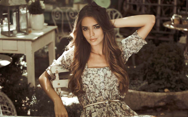 HD desktop wallpaper of Spanish woman Clara Alonso posing outdoors in a floral dress with soft sunlight enhancing the natural, serene setting.