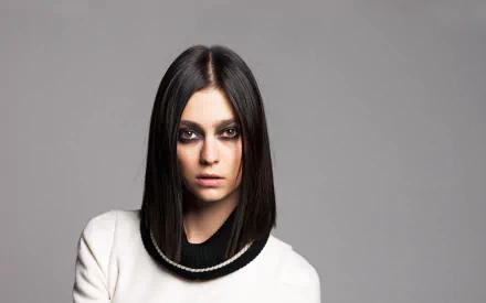 HD PC desktop wallpaper of a French female model with a sleek dark bob, smoky eye makeup and a white top against a neutral gray background.