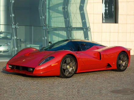 HD desktop wallpaper featuring a sleek red Ferrari Pininfarina P4/5 Concept parked on a modern urban street with glass and stone buildings in the background.