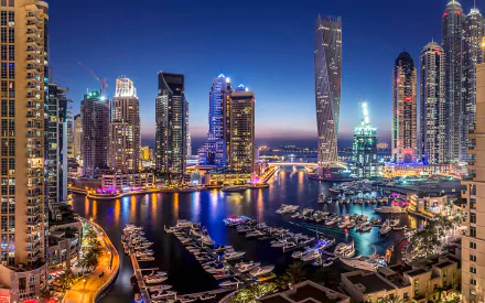 HD image featuring a vibrant Dubai skyline at night, with illuminated skyscrapers and a marina filled with yachts, serving as an exquisite desktop wallpaper and background.