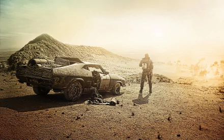 A desolate landscape features Max Rockatansky standing beside a battered car, evoking the intense atmosphere of Mad Max: Fury Road in this striking HD wallpaper.