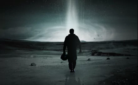A dramatic scene from the movie Interstellar, featuring a figure walking towards a luminous celestial phenomenon, set against a dark, expansive landscape. HD desktop wallpaper.