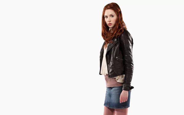HD desktop wallpaper featuring Scottish actress and celebrity Karen Gillan in a leather jacket and denim skirt against a white background.