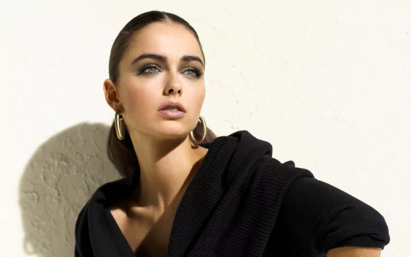 HD desktop wallpaper featuring a brunette model with sleek hair, bold earrings, and a confident expression against a plain background.