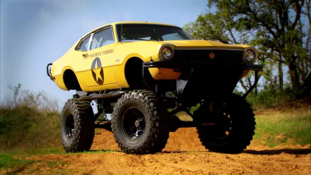 HD Top Gear-themed desktop wallpaper featuring a yellow monster truck on a dirt track.