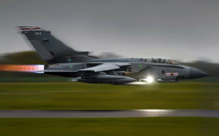 HD desktop wallpaper featuring a Panavia Tornado military jet in motion on a runway under a cloudy sky.