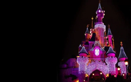 A vibrant, HD wallpaper showcasing the enchanting Disneyland castle adorned with colorful lights against a dark background, capturing the magic of this iconic destination.