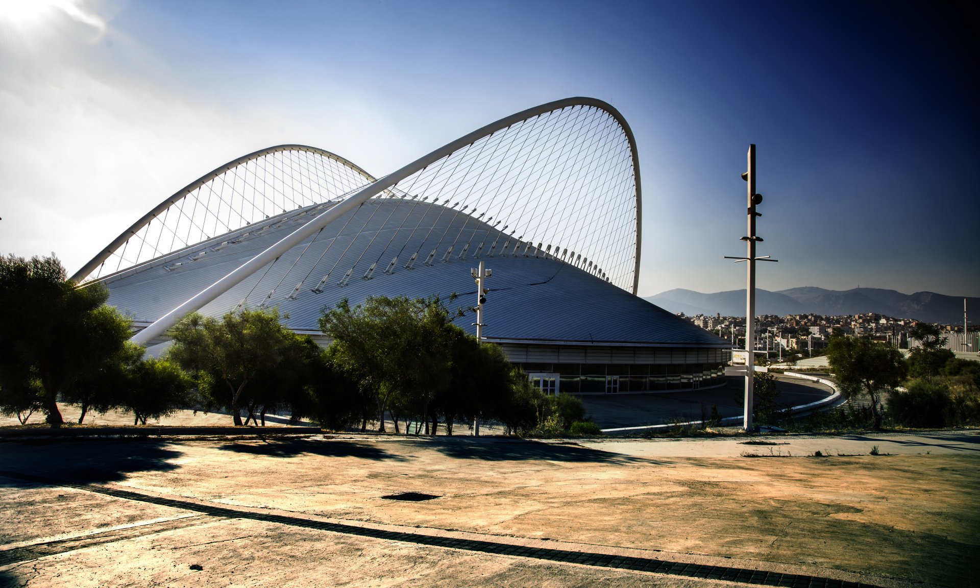 Sunset view of the modern Greek Olympic Park building featuring curved architectural design, captured in vibrant 4K Ultra HD quality.