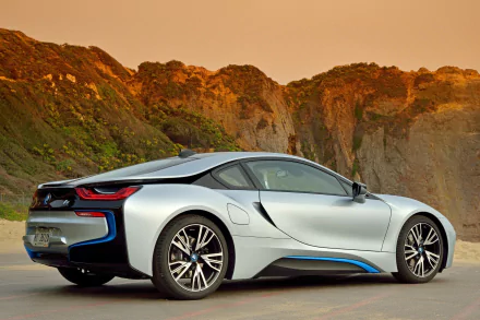 A sleek BMW i8 parked against a stunning coastal backdrop, showcasing its futuristic design and vibrant colors. This HD image serves as a striking desktop wallpaper.