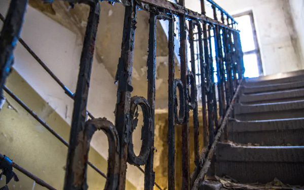 Rusted iron railing and crumbling concrete stairwell in an urban German ruin, HDR 5K Ultra HD desktop wallpaper/background.