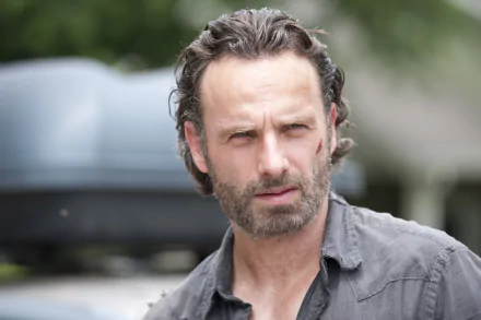 HD desktop wallpaper featuring a close-up of a character from the TV show The Walking Dead with a serious expression and outdoor background.