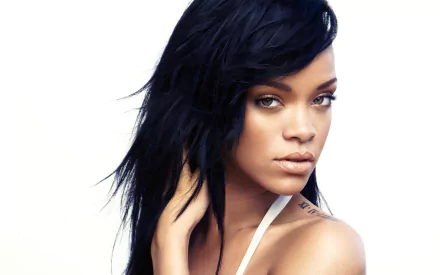 HD PC desktop wallpaper featuring a close-up portrait of Rihanna with natural makeup and tousled black hair, highlighting her music icon status.