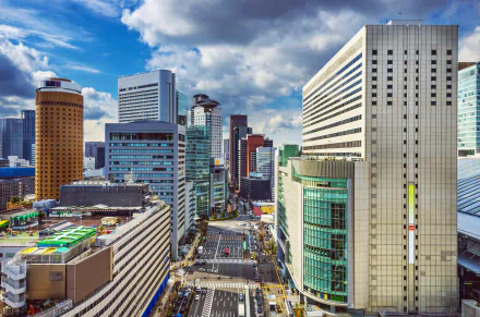 A vibrant skyline of Osaka, Japan, showcasing modern architecture under a dramatic sky. The image captures the city’s dynamic urban landscape in stunning 4K Ultra HD quality.