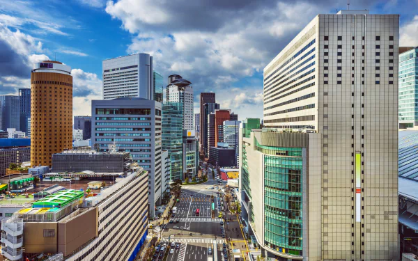A vibrant skyline of Osaka, Japan, showcasing modern architecture under a dramatic sky. The image captures the city’s dynamic urban landscape in stunning 4K Ultra HD quality.