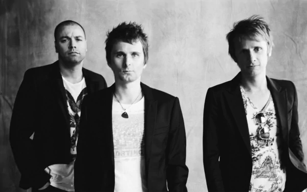 Black and white image of the band Muse, featuring three members standing confidently. This HD desktop wallpaper captures their distinctive rock aesthetic.